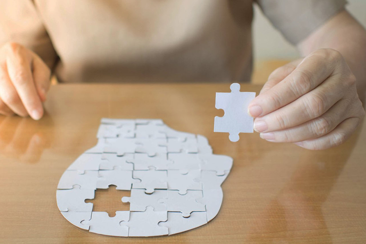 hands-putting-together-puzzle-head