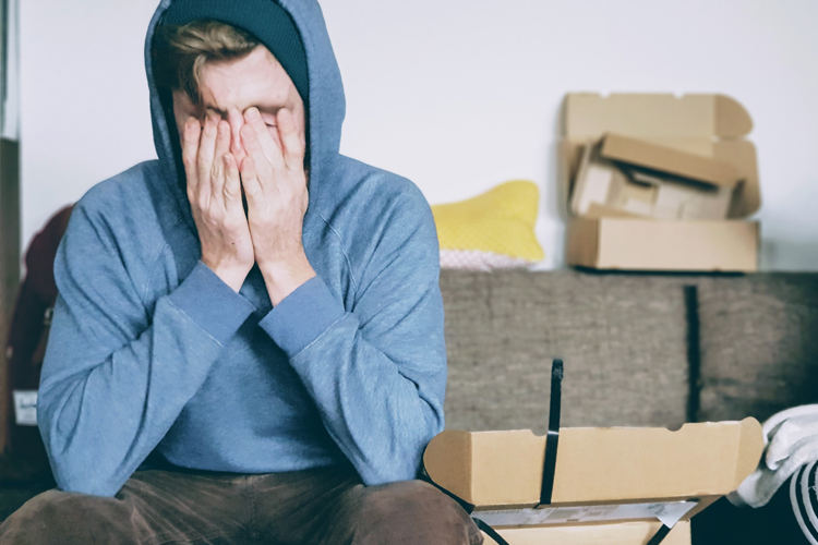 man-with-hands-over-face-open-boxes